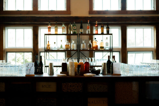 Wedding bar display with bottles and glassware at Riverside Farm