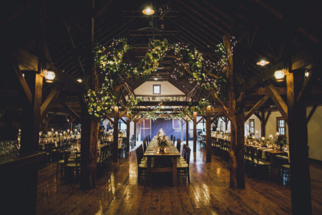 Barn wedding reception with long tables and warm lighting
