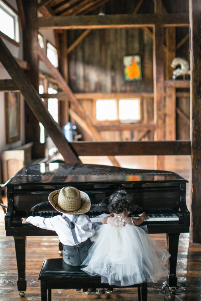 Child playing piano during a wedding at Riverside Farm