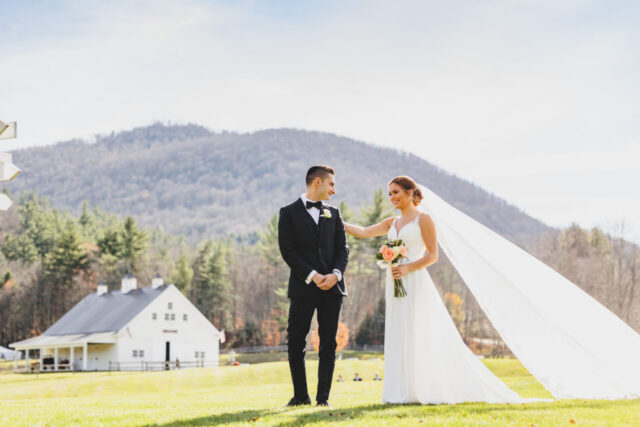 Newlywed couple with a flowing veil in a Vermont meadow