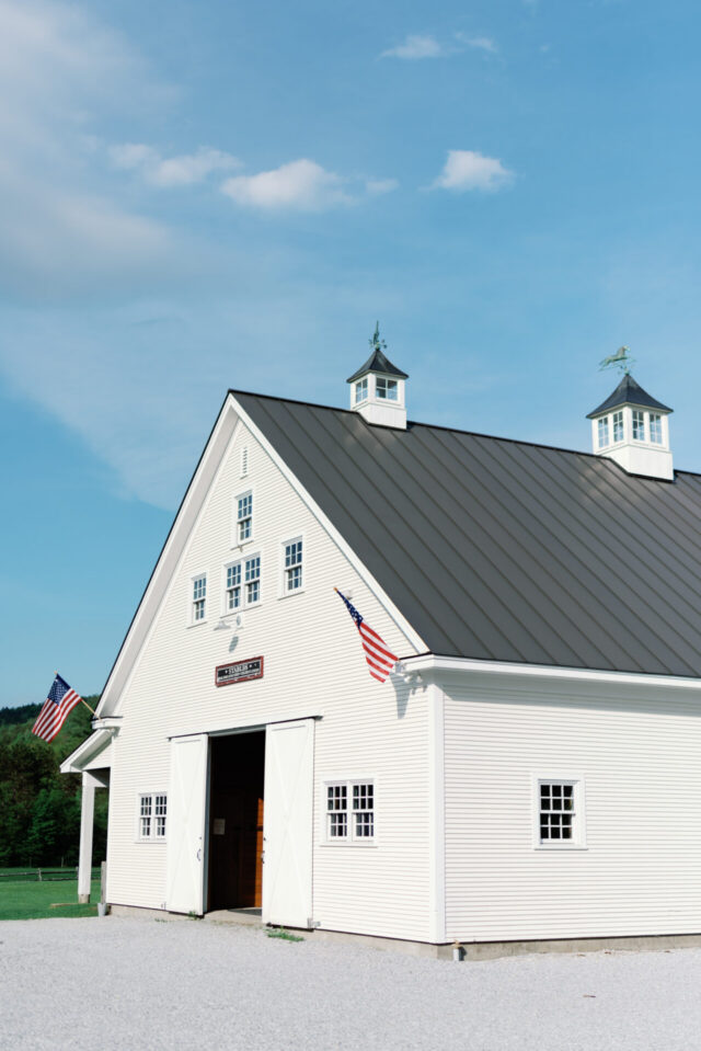 Riverside Farm white barn building and green lawn